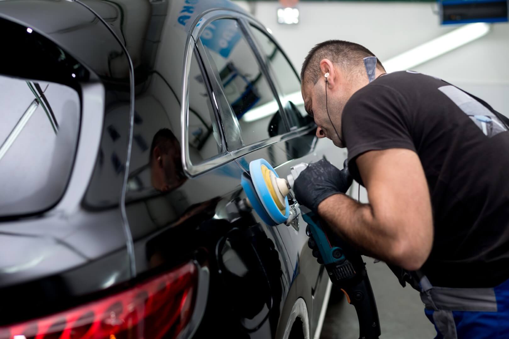 Car detailing expert from Rosedale waxing a car.